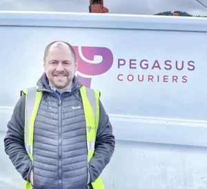 Courier driver Paul Macbeth from Pegasus Couriers stands at a delivery van